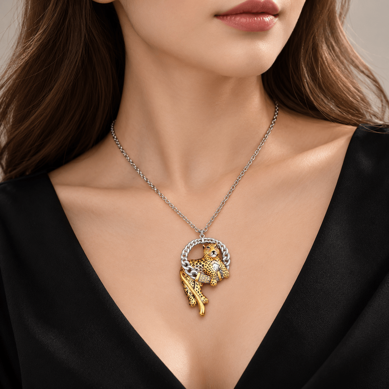 BIRGIE Halskette mit kunstvoll emailliertem Leopardenanhänger, silberfarbener Kette und goldfarbenen Details an einer Frau